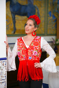 Gilet MANUELA rouge à fleurs multicolores et longues franges, porté sur une blouse blanche – tenue de flamenco